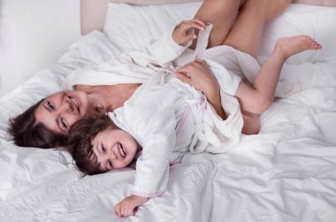 Anne ve kızı yatakta iyi eğlenceler.