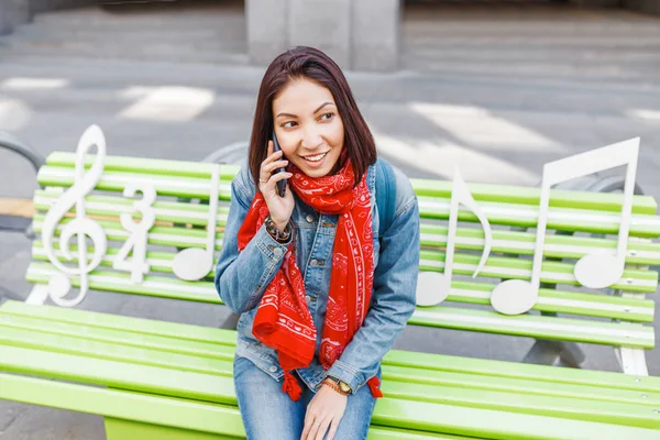Ευτυχισμένος Κορίτσι Καλώντας Στο Κινητό Τηλέφωνο Που Κάθεται Ένα Παγκάκι — Φωτογραφία Αρχείου