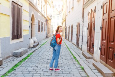 Kadın turist bir sırt çantası ile dar Avrupa sokaklarında dolaşıyor