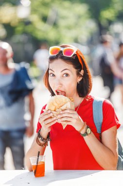 Bir hamburger ve bir meşrubat bir food court şehir meydanında bir kadın gezgin aperatifler