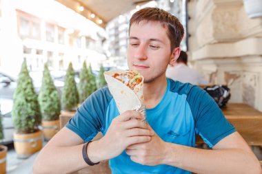 Man eating Doner Kebap its a midlle eastern fast food cuisine clipart