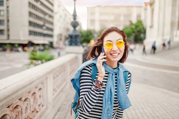 Açık havada şehirdeki sokak telefonda konuşan sırt çantası ile genç ve güzel Asyalı kadın