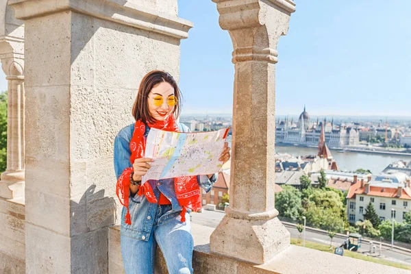 Genç ve güzel Asya seyahat kadın balıkçı Kalesi kale Budapeşte, Macaristan için haritaya bakarak