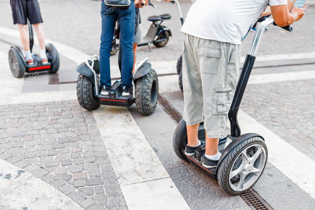 People on the segways in the city, trip on a electronic scooters