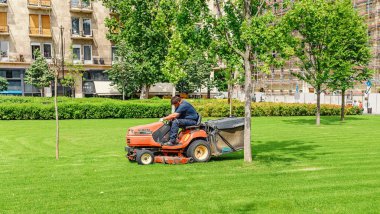 14 Mayıs 2018, Budapeşte, Macaristan: ekipman kavramı bahçe şehir parkı çimenlerin üzerinde çalışan adam sürme çim biçme makinesi mini traktör