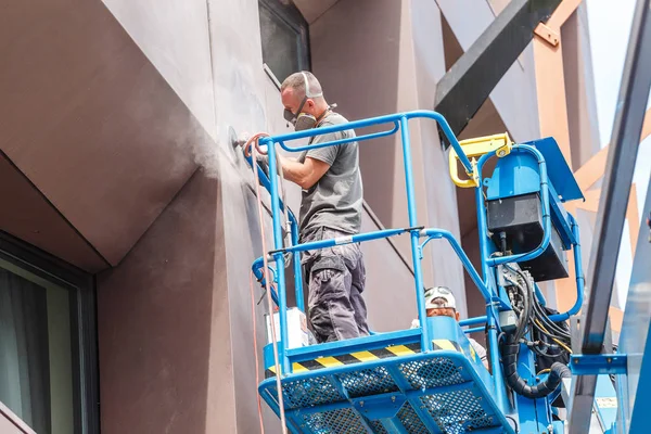 14 Mayıs 2018, Budapeşte, Macaristan: inşaat işçileri geri yükleme için vinç araç kova ve bina cephe onarım