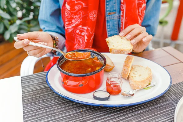 Genç güzel Asyalı kız açık restoranda Macar gulaş çorbası dekoratif kırmızı güveç yemek