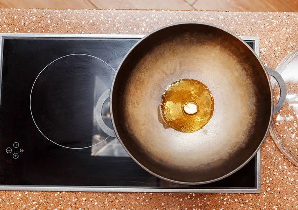 frying pan with oil on an induction cooker top view