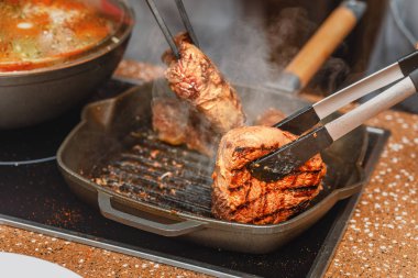 duman dolu bir ızgara tava pişirme lezzetli sığır eti biftek