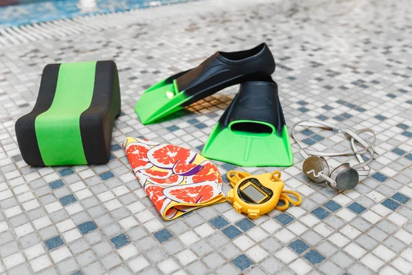 Swimming sport equipment: swim cap, goggles flippers and stopwatch