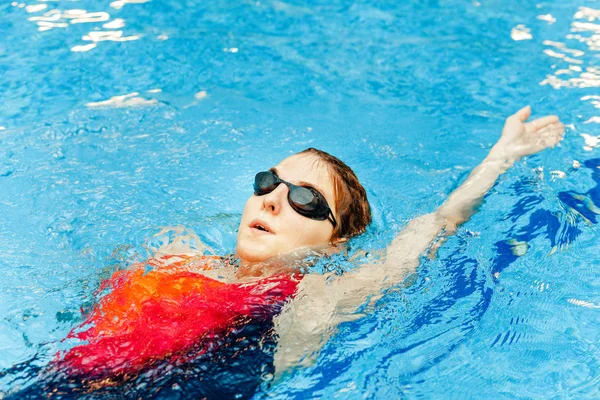 年轻的女运动员在一个蓝色的健身馆游泳池里运动 — 图库照片