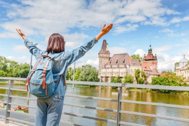 Vajdahunyad castle ve Budapeşte gölde bir arka plan üzerinde bir genç mutlu traveler kız duruyor