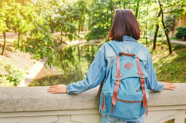 Genç esmer kadın park Budapeşte'de seyahat ve eski kanalı üzerinden bir köprüde duran güzel