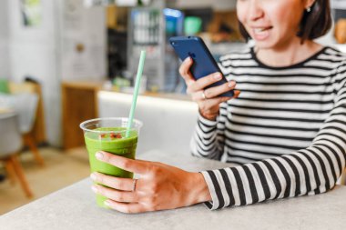 Genç kadın vejetaryen ve vegan yeşil smoothies goji meyveleri ile içecekler