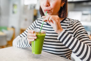 Genç kadın vejetaryen ve vegan yeşil smoothies goji meyveleri ile içecekler
