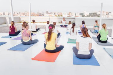 01 Temmuz 2018, Ufa, Rusya Federasyonu: bir grup insan çatıda yoga egzersiz yaparken poses asana