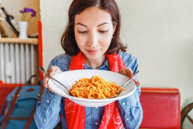 Genç kadın yerel restoranda geleneksel İtalyan makarna yemek