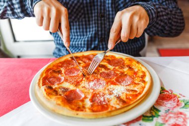 İtalyan restoranında çatal ve bıçak kullanarak mutlu aç adam yeme pizza