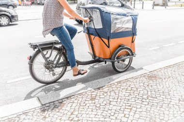 Genç Anne binicilik bisiklet bebek bisiklet römork, yoğun şehir sokak, yol emniyet konsepti ile