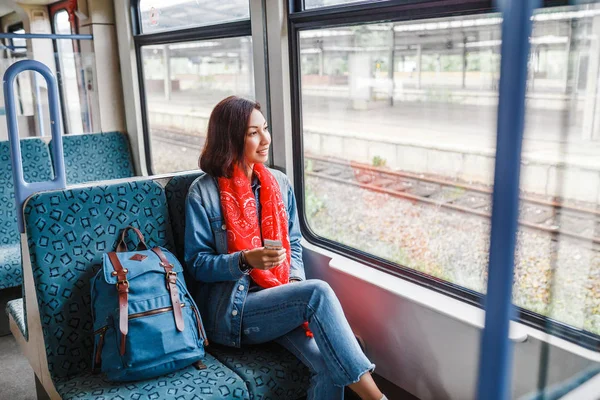 Asian Lady with backpack travels in train