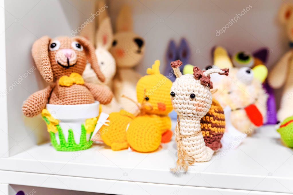 Various knitted animals toys on a shelf at home or for sale at baby shop