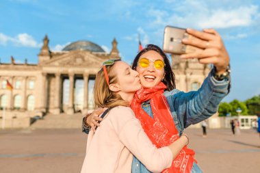 İki mutlu kadın Reichstag Bundestag Berlin'de Bina arka plan üzerinde selfie yapma. Avrupa'da seyahat ve aşk kavramı