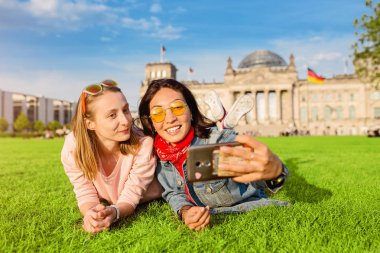 İki mutlu kadın Reichstag Bundestag Berlin'de Bina arka plan üzerinde selfie yapma. Avrupa'da seyahat ve aşk kavramı