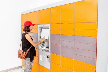 Self servis sonrası terminal makine ya da soyunma bir paket almak için veya Bagaj muhafazası için yatırmak için kadın istemci kullanarak otomatik
