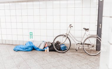 Berlin, Almanya - 19 Mayıs 2018: serseri Metro onun bisiklet ile uyku tulumu içinde uyur