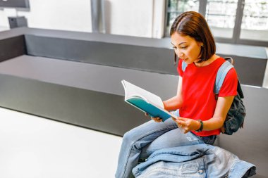kız öğrenci bir modern Kütüphane iç Üniversitesi'nde bir kitap okuma