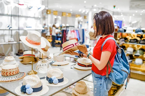 亚洲妇女在购物中心尝试帽子和取笑 — 图库照片