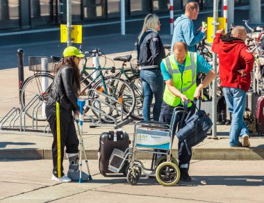 Berlin, Almanya, 20 Mayıs 2018: Yardımcısı kadın Schonefeld Airport Terminal yakınındaki otobüs istasyonu'na Başlarken bir tekerlekli sandalye üzerinde yardım