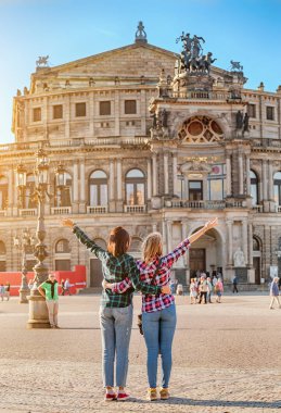 Dresden, Almanya - 20 Mayıs 2018: sarılma ve Semper Opera Tiyatrosu Dresden manzarasına hayran iki mutlu kadın arkadaş