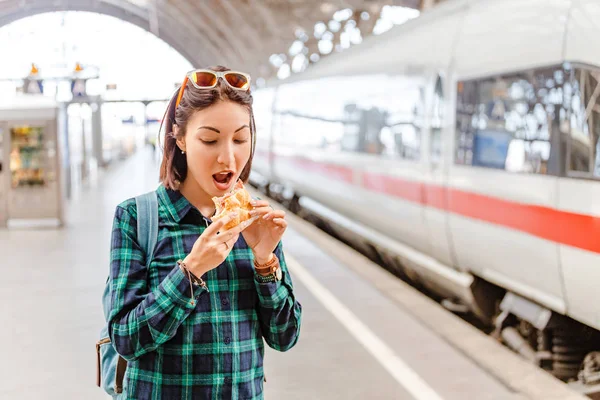 Здоровая Молодая Женщина Кусает Гамбургер Вокзале Возле Скоростного Поезда — стоковое фото