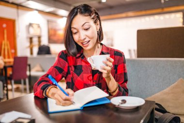 İş serbest kadın veya hipster öğrenci ile çekici notlar kafede kahve fincanı