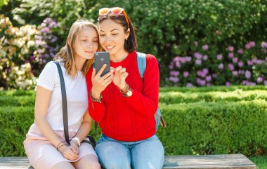Kadın arkadaşlar açık havada Park akıllı telefon içerik paylaşımı