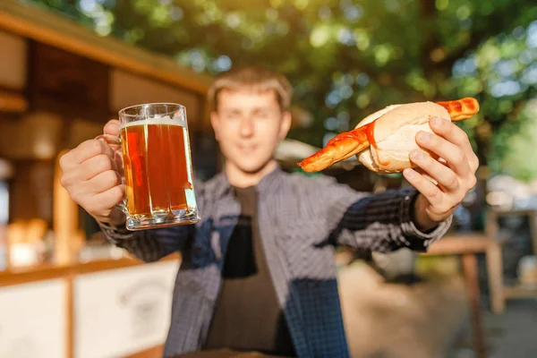 Mladý Muž Pití Piva Venkovní Kavárna Jíst Hot Dogy — Stock fotografie
