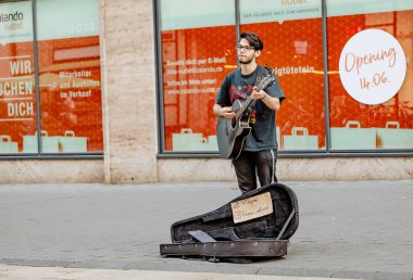 22 Mayıs 2018, Leipzig, Almanya: genç hipster adam sokakta gitar çalıyor. Rock tarzı