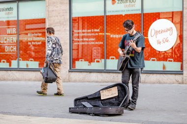 22 Mayıs 2018, Leipzig, Almanya: genç hipster adam sokakta gitar çalıyor. Rock tarzı