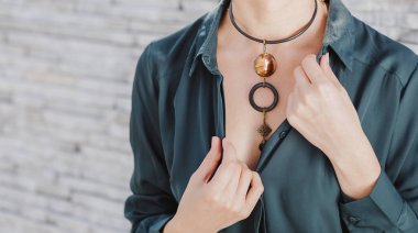 yakın çekim portre şık el yapımı takı kolye giyen güzel bir kadın. Moda aksesuarları kavramı