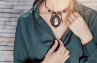 yakın çekim portre şık el yapımı takı kolye giyen güzel bir kadın. Moda aksesuarları kavramı