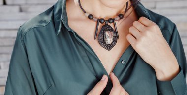 yakın çekim portre şık el yapımı takı kolye giyen güzel bir kadın. Moda aksesuarları kavramı