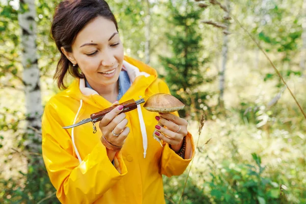 Bir kadında parlak sarı ceket malzeme çekme sonbahar bir ormanda ve mantar. Açık rekreasyon kavramı