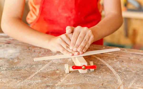 小男孩手工创作木制飞机玩具在木工 儿童木制品类及创意概念 — 图库照片