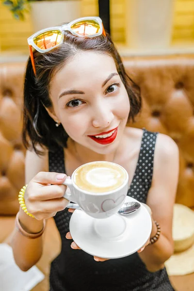 Женщина в кафе пьет кофе — стоковое фото