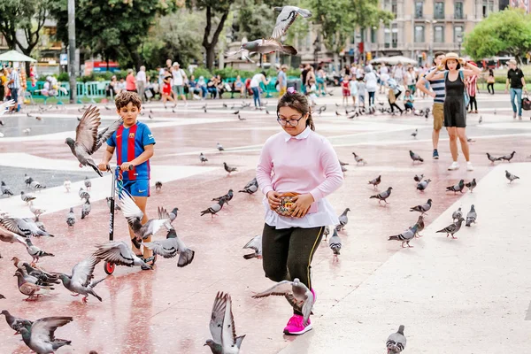 10 LUGLIO 2018, BARCELLONA, SPAGNA: Ragazza che gioca con le colombe nella piazza della città — Foto Stock