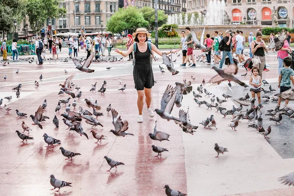 10 LUGLIO 2018, BARCELLONA, SPAGNA: Ragazza che gioca con le colombe nella piazza della città — Foto Stock