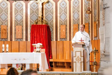 12 JULY 2018, BARCELONA, SPAIN: catholic priest says prayers during ceremony or mass in Tibidabo Church clipart