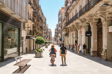 17 JULY 2018, REUS, SPAIN: Central pedestrian Street of Reus on hot sunny day with people clipart