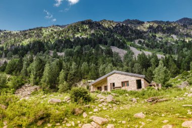 A public stone house is an open free shelter for all travelers and hikers in the mountains of the Pyrenees clipart